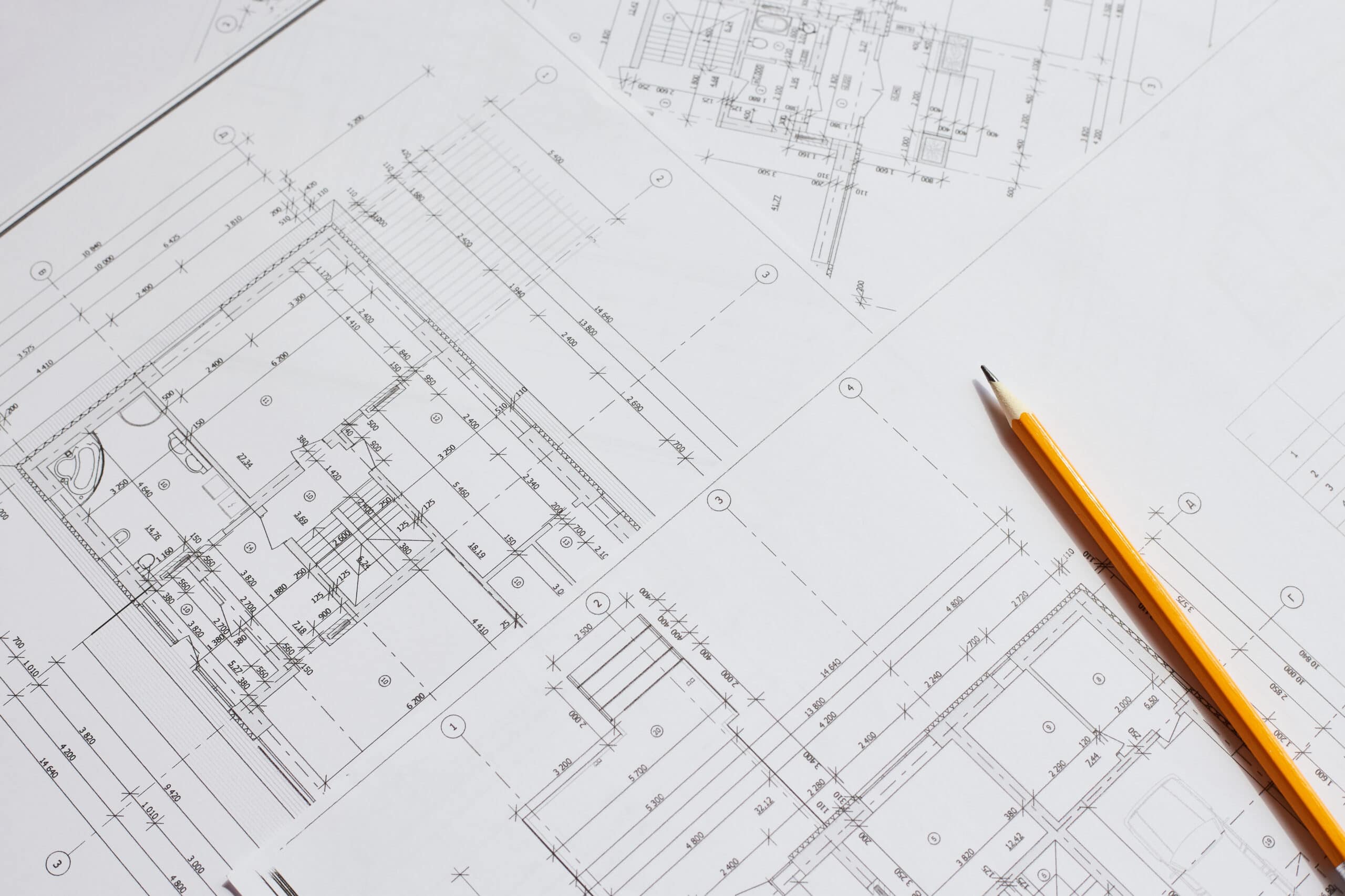 pencil and office tools for writing on the blueprint of construction industry. Place the rolls on a desk over blurred blueprint for construction industry background. construction industry concept.